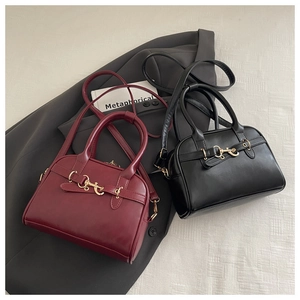 Detail view of retro leather bowling bags in dark red and black with golden metal hardware