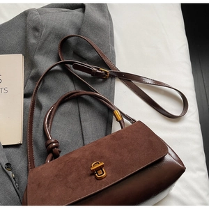 Detailed view of brown suede and leather splicing handbag with vintage gold buckle
