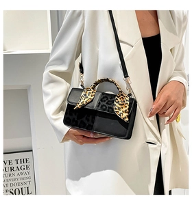 Detail of crossbody bag with leopard print scarf handle and adjustable shoulder strap