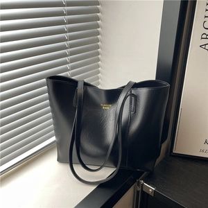 Minimalist black faux leather tote bag with gold lettering for daily office commute