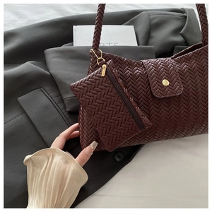 Detail of dark red woven underarm bag with matching coin purse on a grey suit