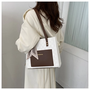 Detail of white checkered tote bag with brown leather trim and printed silk scarf