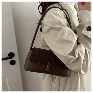 Side view of vintage leopard print suede baguette bag styled with a beige trench coat