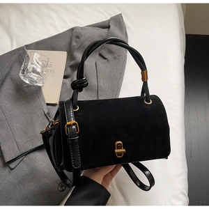 Detail of black suede and smooth leather crossbody bag with vintage golden clasp