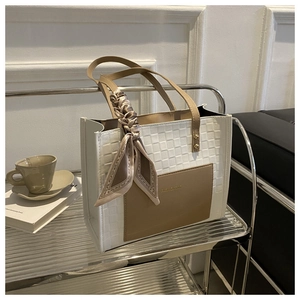 Detailed view of checkered tote bag featuring a decorative silk scarf on the handle