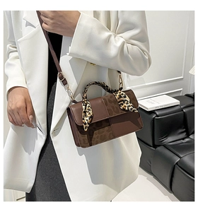 Brown leather handbag with leopard print flap and silk scarf detail on handle