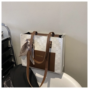 Detail of checkered white and brown tote bag with silk scarf and gold fashion text