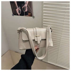 Dettaglio borsa baguette beige con fibbia in metallo e sottile tracolla in ecopelle