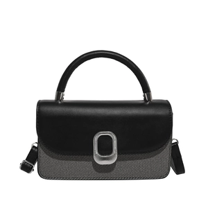 Sac à main chic bicolore en cuir noir et tissu texturé avec fermoir en métal argenté