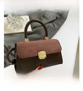 Detail of vintage tote bag featuring contrasting leather textures and gold metal clasp