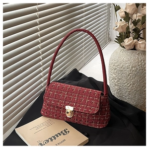 Detail of red tweed shoulder bag with gold thread weave and metal push-lock buckle