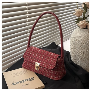 Detail of red tweed shoulder bag with golden metallic clasp on vintage background