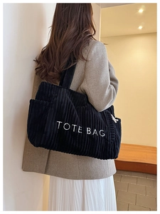 Nahaufnahme der schwarzen Cord-Einkaufstasche mit weißer TOTE BAG Stickerei und Textur