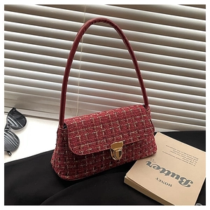 Close-up of red bouclé shoulder bag with gold metallic threads and a golden buckle