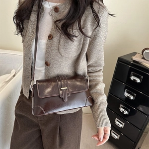 Borsa baguette retrò in pelle marrone scuro con cuciture a contrasto su un modello