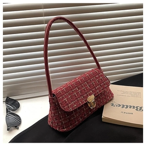 Close-up of deep red tweed underarm bag with gold metallic weaving and hardware