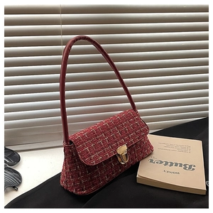 Detail of red tweed shoulder bag texture with golden metallic buckle and leather strap