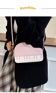 Detail of creative piano-shaped pink crossbody bag with polka dots and keyboard pattern