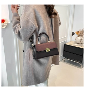 Detail showing mixed texture color-block handbag with gold buckle on a model shoulder
