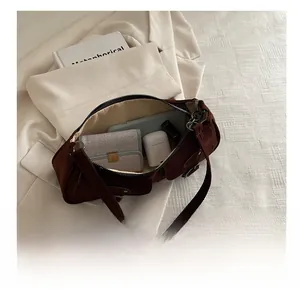 Vue intérieure du sac bandoulière en daim marron avec rangement pour cosmétiques