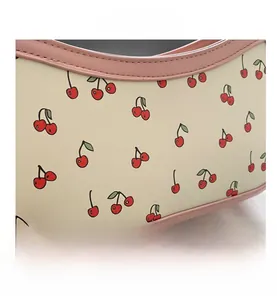 Close-up of sweet cherry print on off-white fabric with pink leather trim and stitching