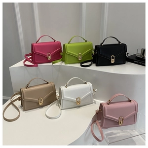 Detail view of colorful PU leather crossbody bags with V-shaped stitching and gold metal locks