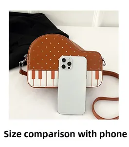 Piano theme crossbody bag size comparison with a smartphone showing internal storage space