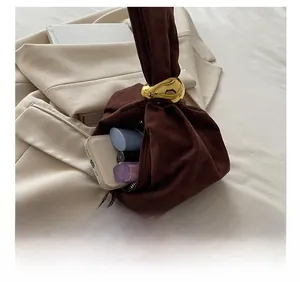 Detail shot of brown suede bucket bag interior showing capacity for phone and lipstick
