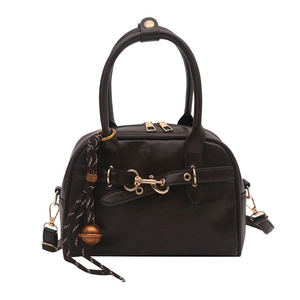 Retro deep brown handbag with gold hardware and woven pendant, 45-degree front view