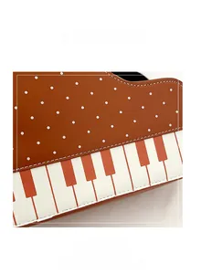 Detailed macro shot of piano key patterns and brown polka dots on a PU leather bag