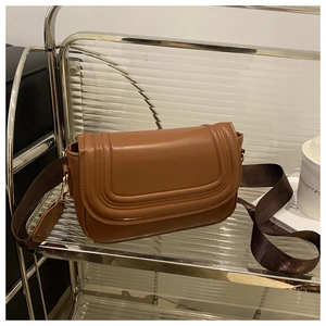 Detail of brown saddle bag showing smooth PU leather and triple decorative stitching