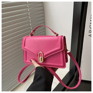 Detail of rose pink mini handbag featuring smooth PU leather and gold oval twist lock