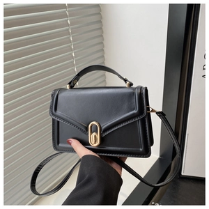 Close-up of black PU leather handbag featuring elegant gold oval lock and top handle