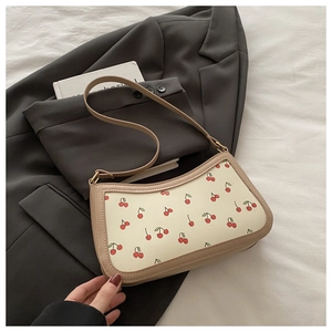 Detailed view of the trendy cherry print on ivory PU leather with khaki trim detail