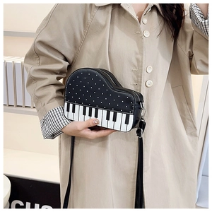Detail view of piano key crossbody bag featuring polka dots and creative musical design