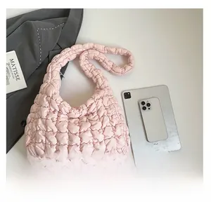 Pink quilted puffer bag shown next to an iPad for scale and size comparison
