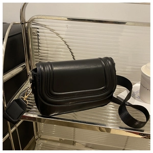 Detail of a black matte leather saddle bag with U-shaped stitching and wide strap