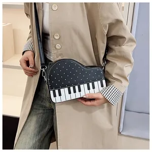 Detail of creative piano-themed crossbody bag with keyboard design and polka dot patterns