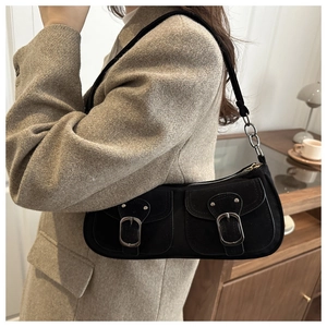 Détail du sac sous l'aisselle vintage noir avec double poche à rabat et boucles argentées