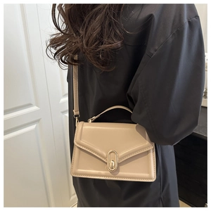 Creamy leather crossbody bag styled with elegant outfit in a modern home interior