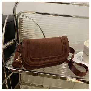 Detail of retro dark brown suede saddle bag with adjustable wide nylon shoulder strap