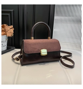 Detail of retro contrast leather handbag with suede flap and gold metal square clasp