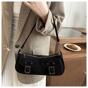 Détail d'un sac sous le bras en daim noir vintage avec boucles argentées en situation