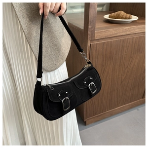 Gros plan du sac sous le bras en daim noir avec boucles argentées et détails de chaîne