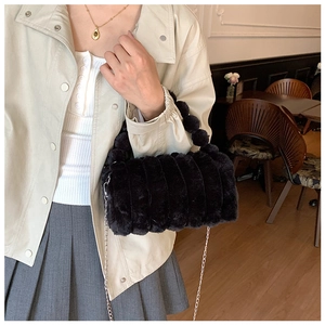 Détail du sac à bandoulière en fausse fourrure noire avec matelassage vertical