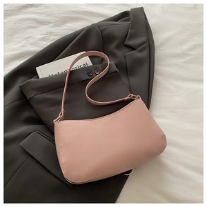 Detailed close-up of pink leather underarm bag with gold hardware on a stylish background