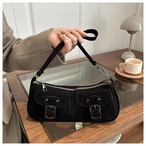 Détail du sac sous le bras noir mat avec doubles poches et bandoulière en chaîne métal