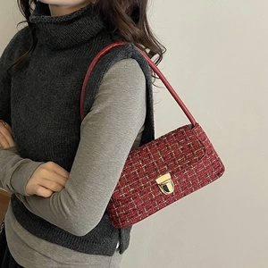 Red tweed shoulder bag with gold thread and metal lock shown on a model