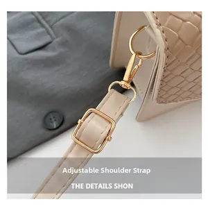 Detail of adjustable shoulder strap and light gold hardware on beige woven handbag