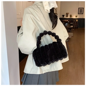 Détail du sac à main noir en fausse fourrure avec poignée perlée et chaîne argent